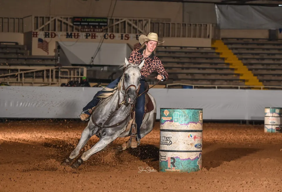 Gray barrel horse Rocky turning a barrel
